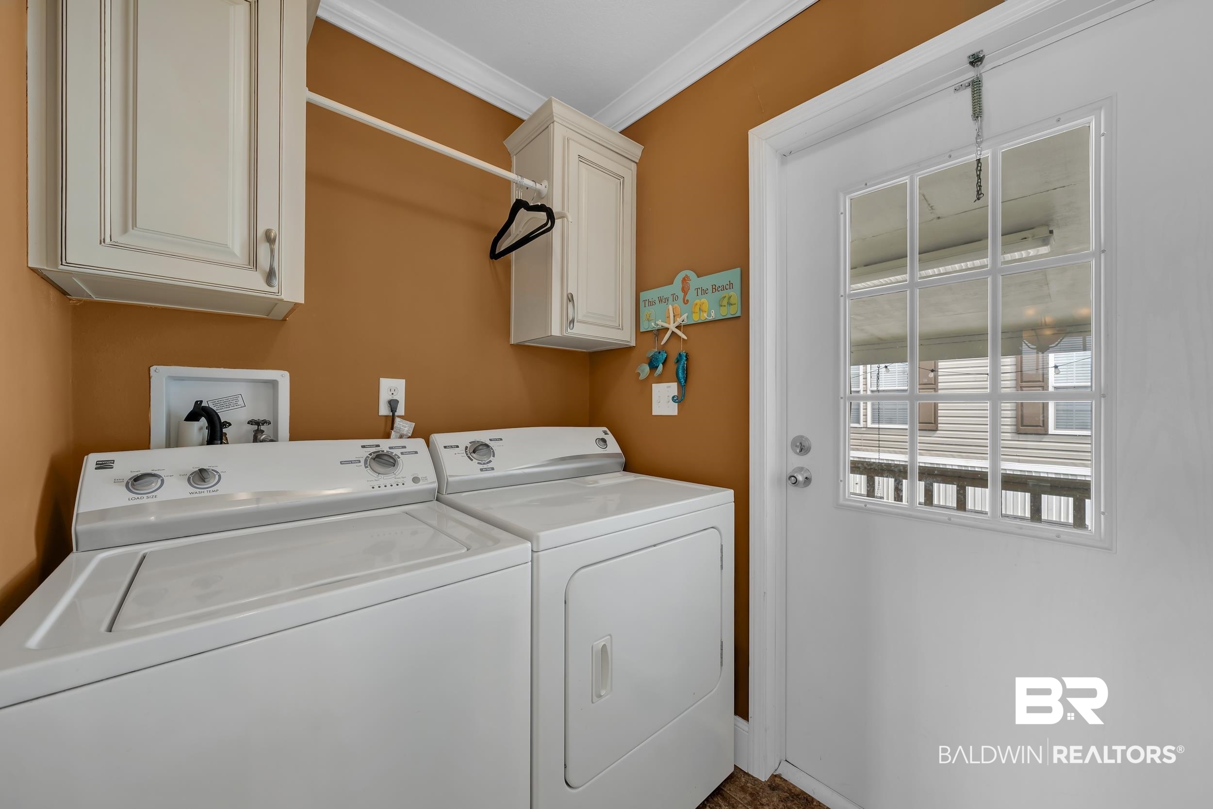16707 Fort Morgan Road, Unit 8 Gulf Shores, AL 36542 - Photo 26 of 27 Washroom with cabinet space, crown molding, and washer and clothes dryer