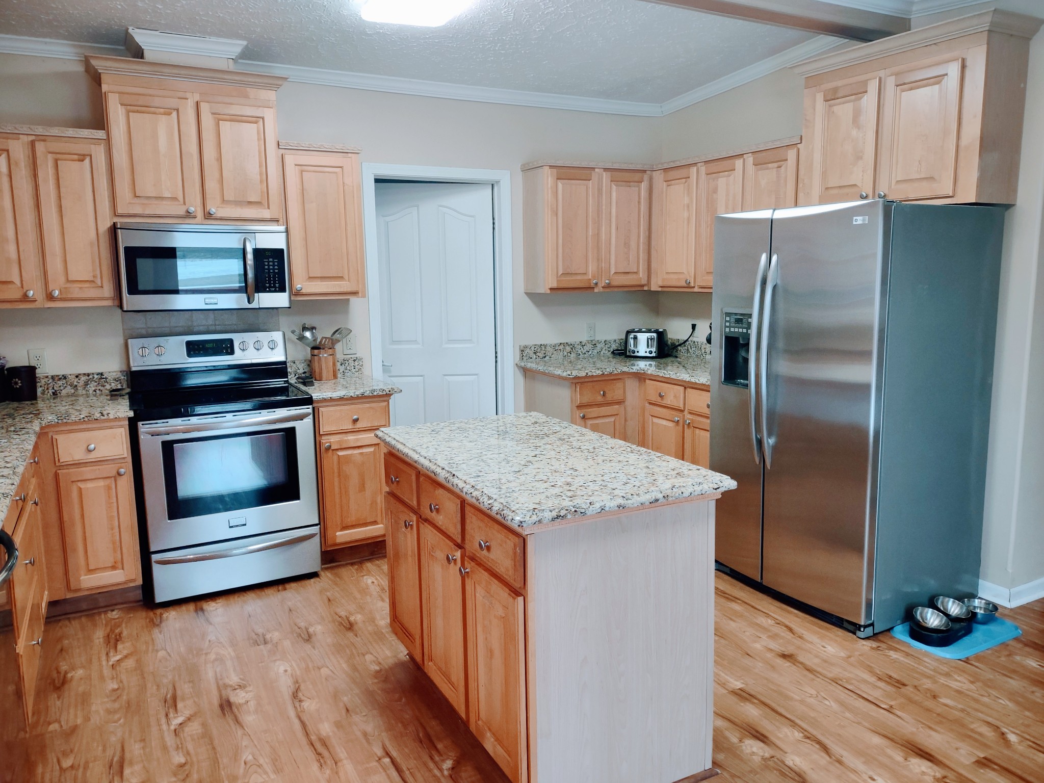 6841 Bethel Road Goodlettsville, TN 37072 - Photo 15 of 27 a kitchen with granite countertop a refrigerator stove and wooden cabinets