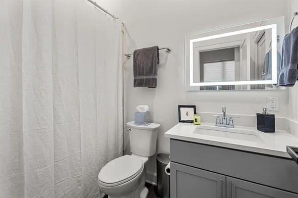 a bathroom with a toilet a sink and mirror