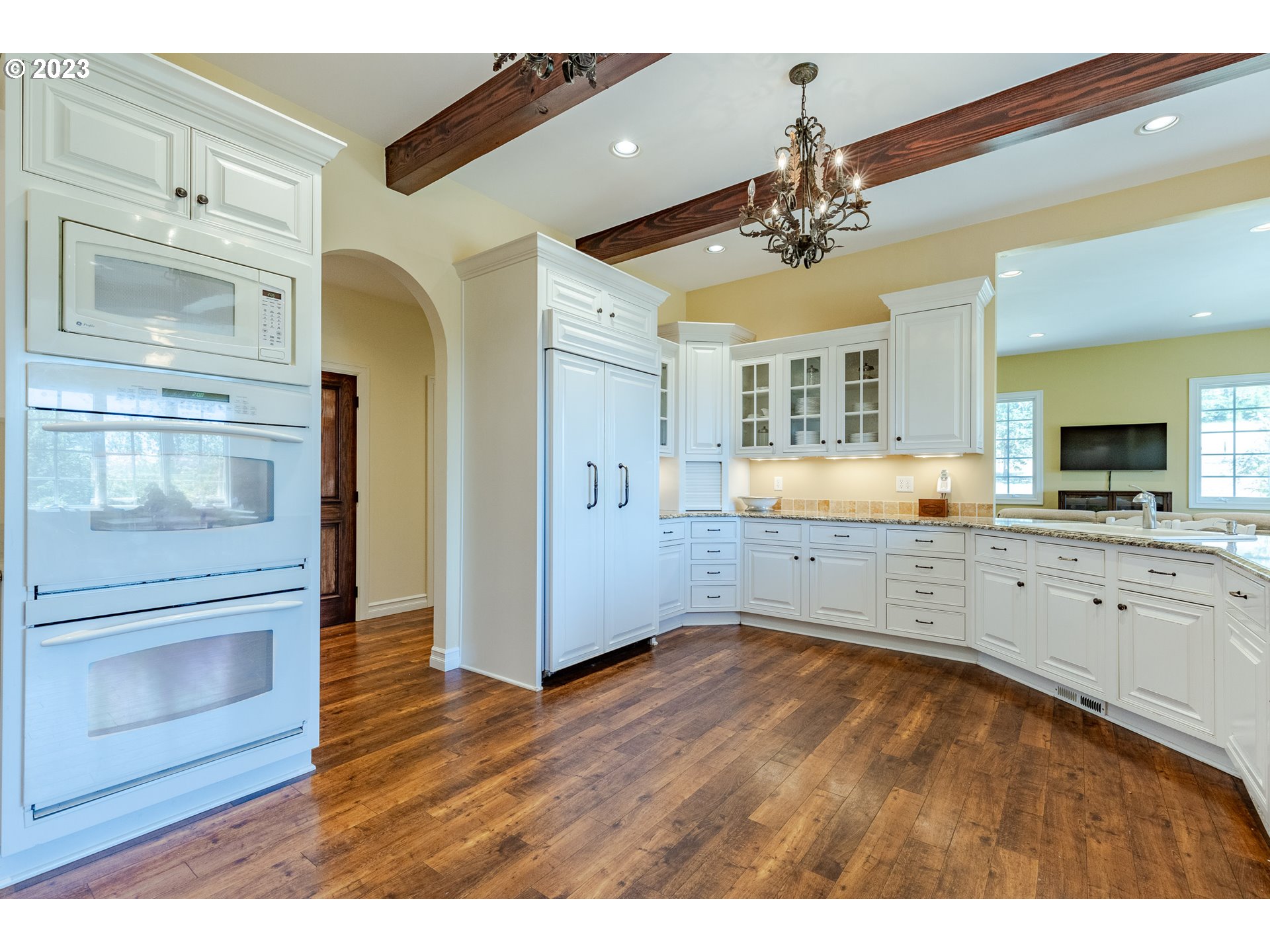 86705 Pine Grove Road Eugene, OR 97402 - Photo 23 of 48 a view of a kitchen with a refrigerator cabinet a fireplace and wooden floor