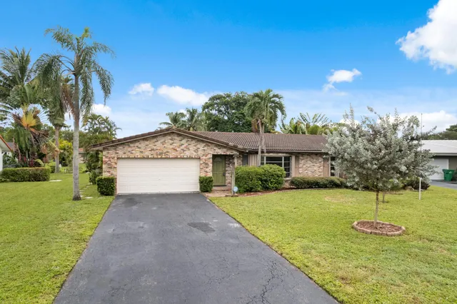 a view of a house with backyard and a tree
