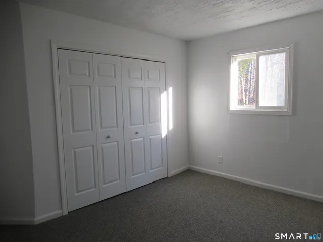 an empty room with a window and wooden floor