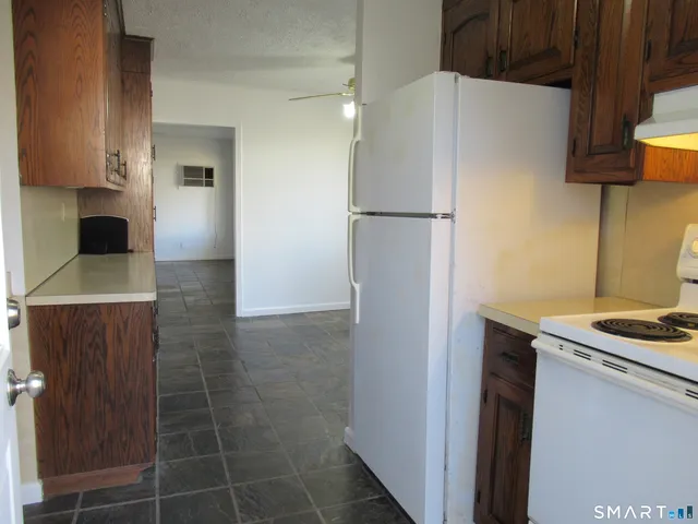 a kitchen with a refrigerator and a stove top oven