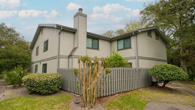 a white house that has tree in front of it
