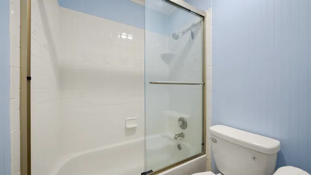 a white toilet sitting next to a bath tub