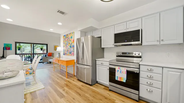 a kitchen with stainless steel appliances a stove a refrigerator and a cabinets