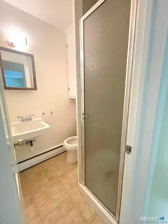 a bathroom with a granite countertop sink toilet and shower
