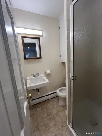 a bathroom with a toilet a sink and mirror