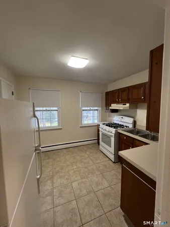 a kitchen with granite countertop a refrigerator and a stove top oven