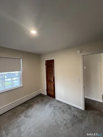 an empty room with windows and closet