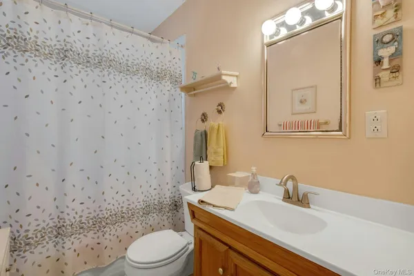 a bathroom with a granite countertop toilet sink mirror and shower