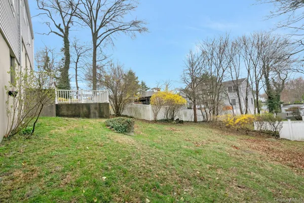 a backyard of a house with plants and large trees