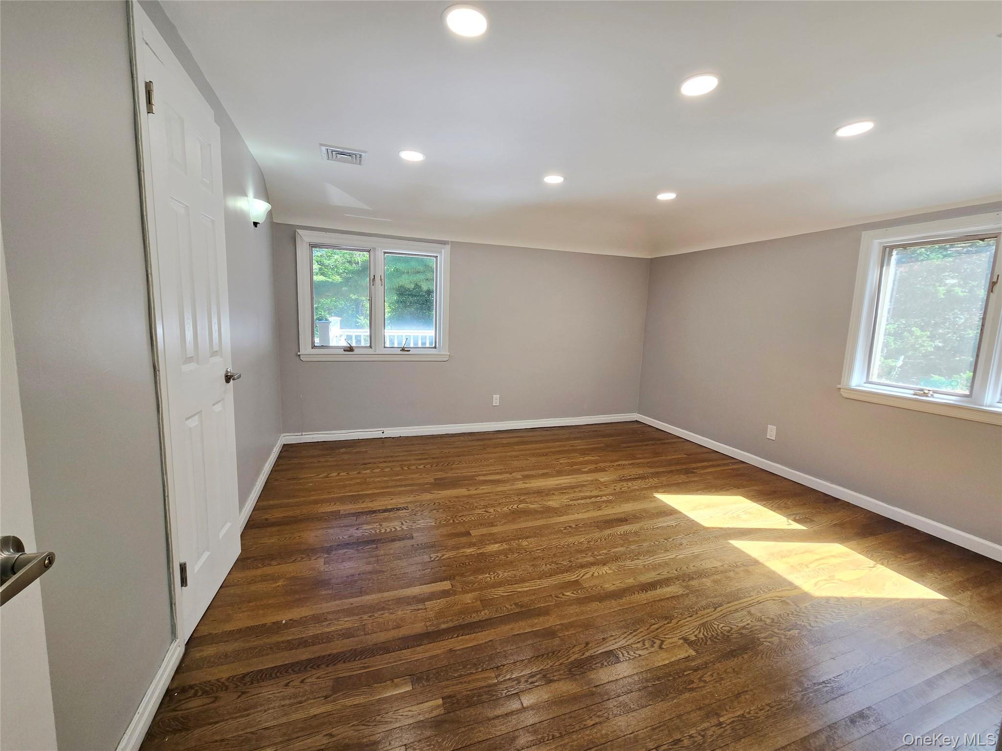 32 Valley Road Old Westbury, NY 11568 - Photo 24 of 45 Unfurnished room with dark wood-style flooring, healthy amount of natural light, and recessed lighting