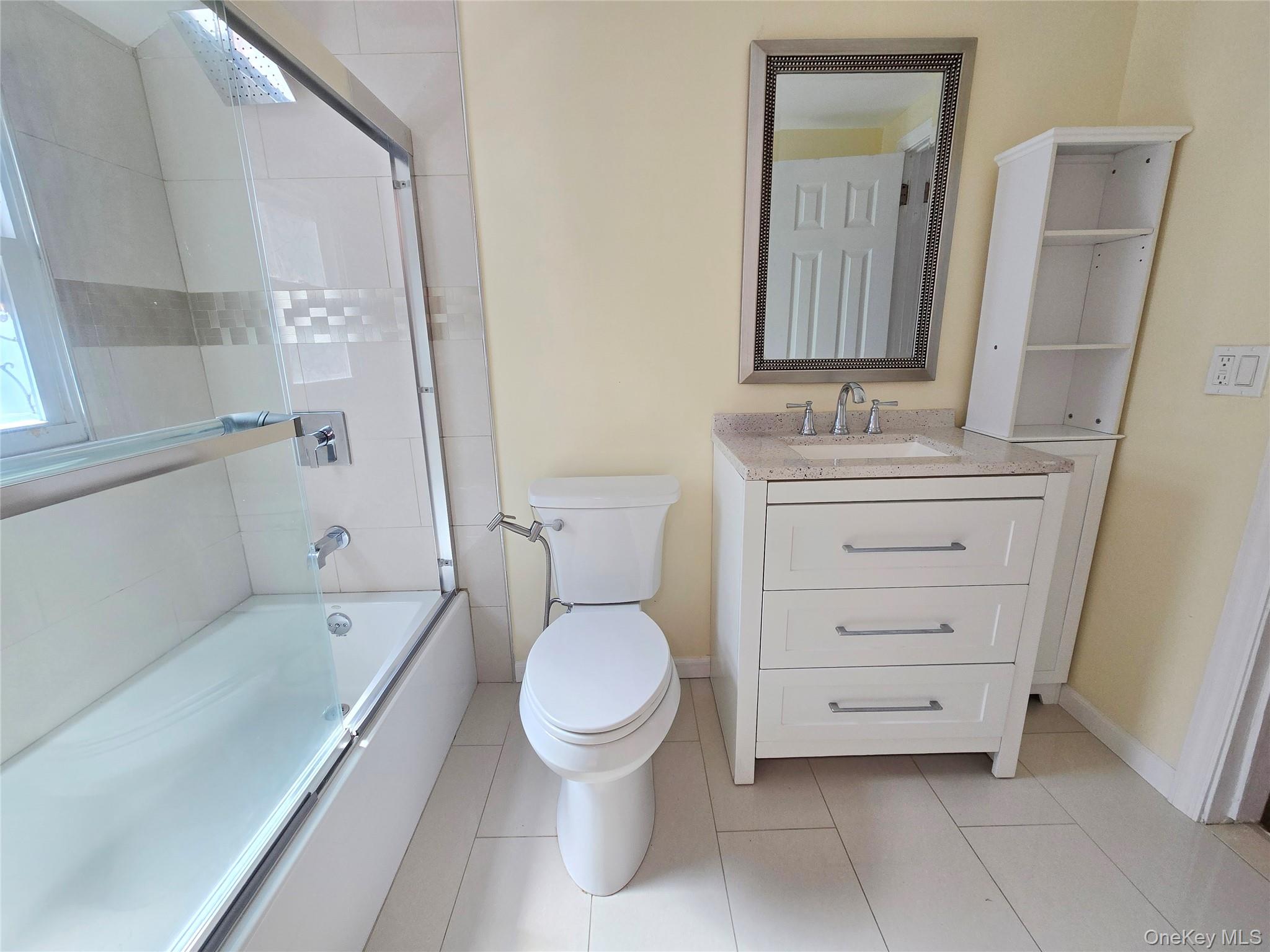 32 Valley Road Old Westbury, NY 11568 - Photo 27 of 45 Full bath featuring combined bath / shower with glass door, vanity, and light tile patterned flooring