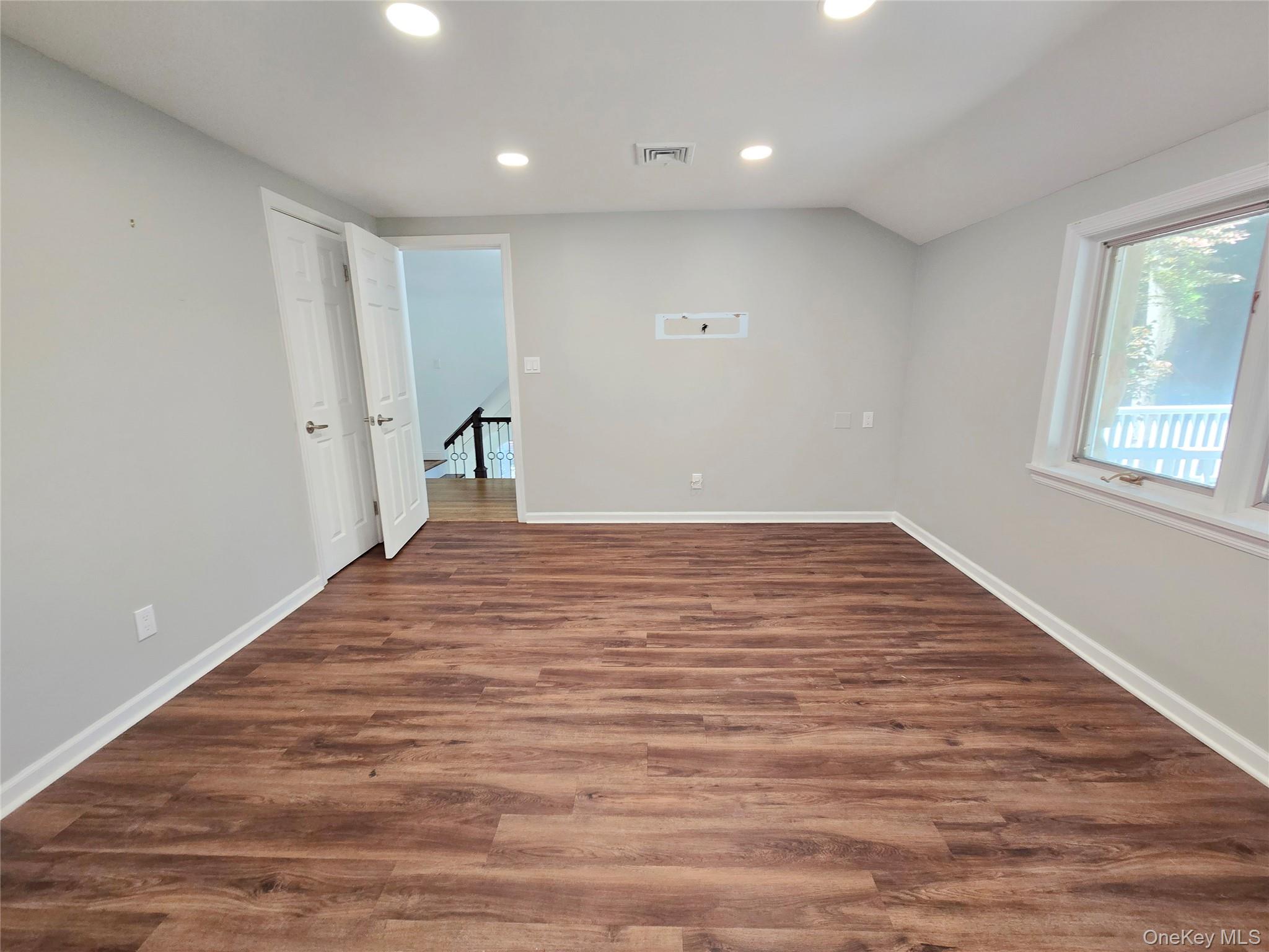 32 Valley Road Old Westbury, NY 11568 - Photo 30 of 45 Empty room with recessed lighting, dark wood-style floors, and vaulted ceiling