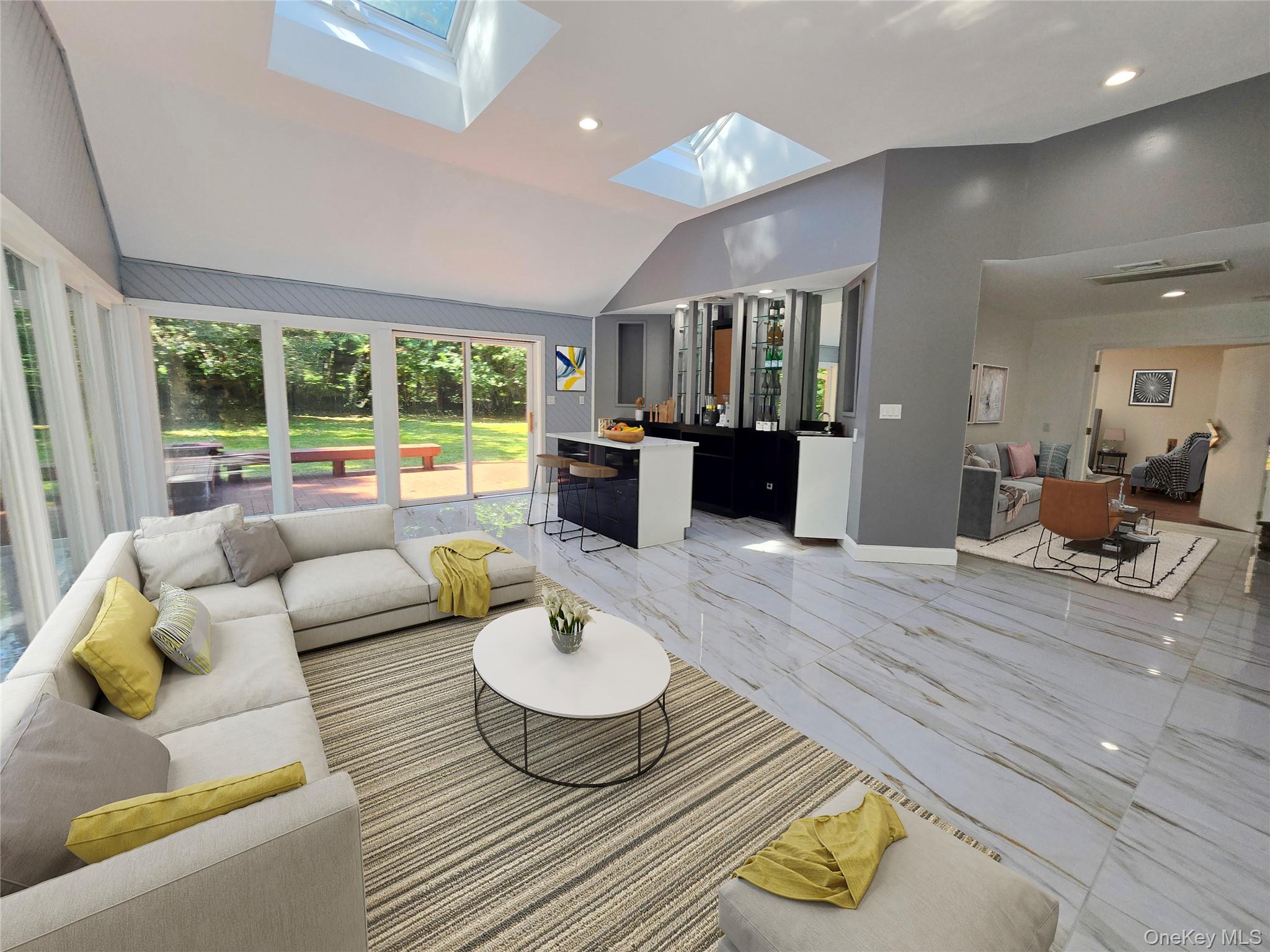 32 Valley Road Old Westbury, NY 11568 - Photo 36 of 45 Living room featuring vaulted ceiling, light marble finish flooring, recessed lighting, and a skylight