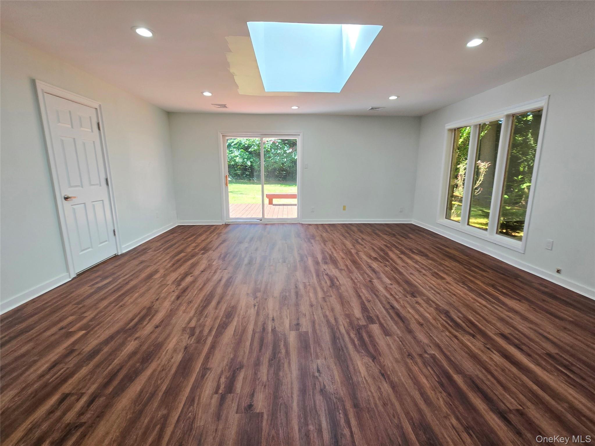 32 Valley Road Old Westbury, NY 11568 - Photo 41 of 45 Unfurnished room featuring a skylight, recessed lighting, and dark wood-style floors