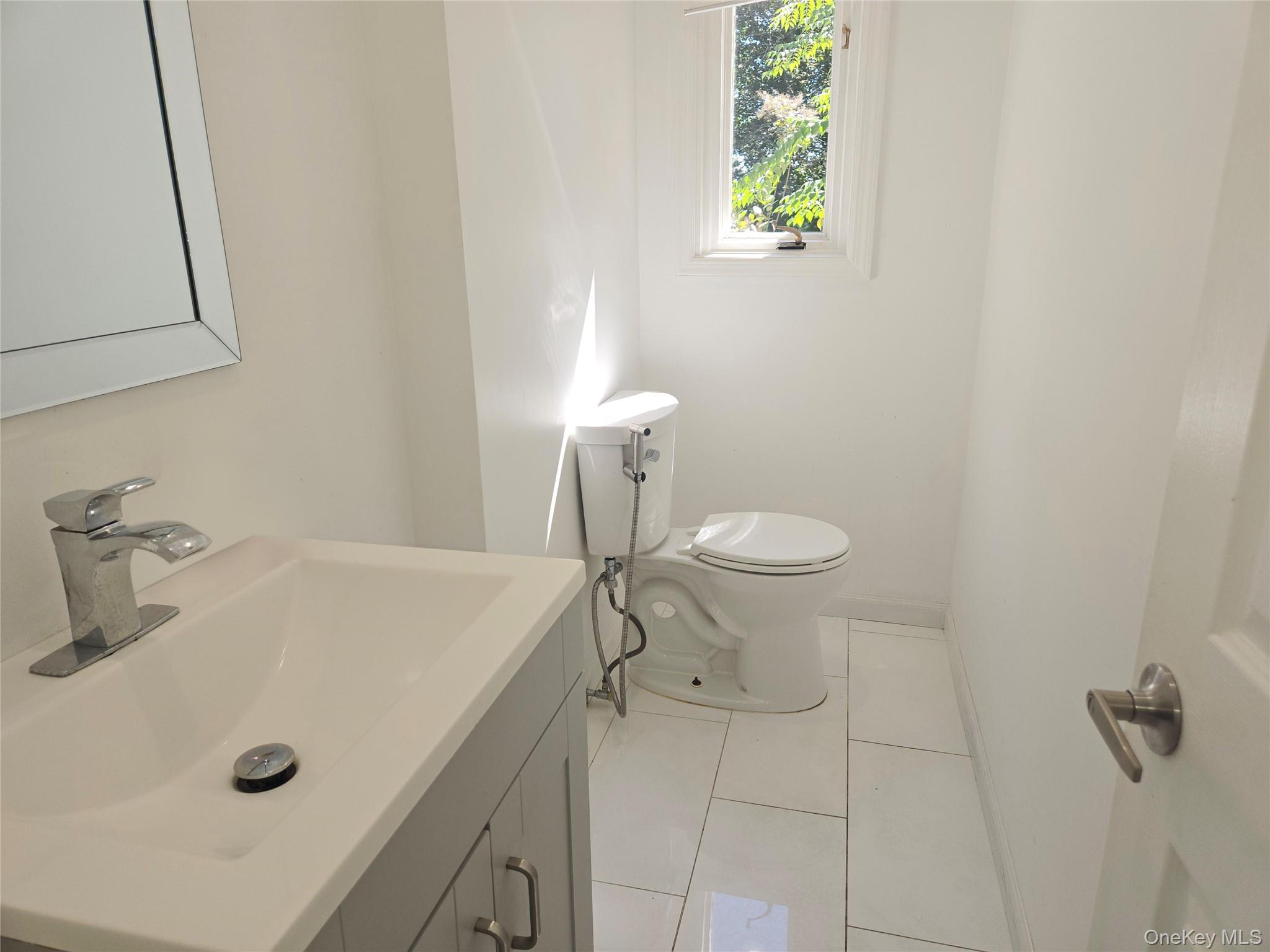 32 Valley Road Old Westbury, NY 11568 - Photo 43 of 45 Half bath with light tile patterned floors and vanity