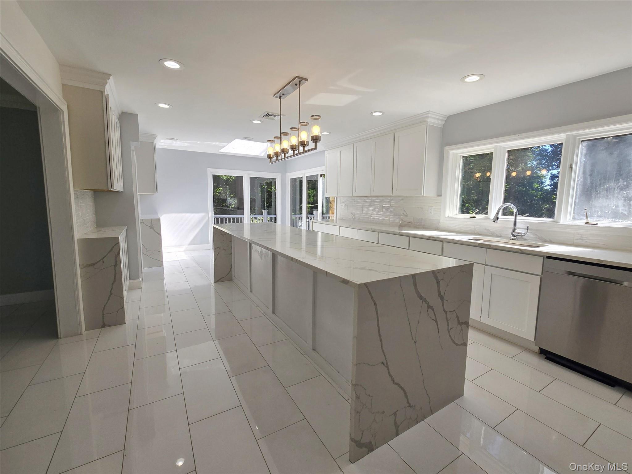 32 Valley Road Old Westbury, NY 11568 - Photo 44 of 45 Kitchen featuring white cabinets, stainless steel dishwasher, backsplash, light stone counters, and recessed lighting