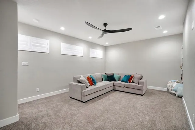 a living room with furniture and a ceiling fan