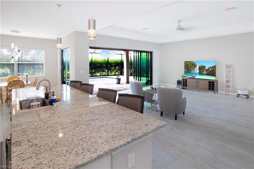 11726 Canopy Loop Fort Myers, FL 33913 - Photo 11 of 40 Kitchen featuring hanging light fixtures, white cabinets, a kitchen island with sink, and plenty of natural light