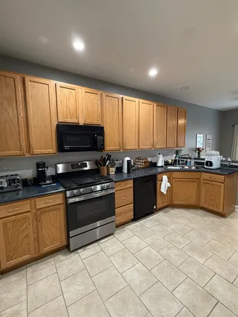 a kitchen with stainless steel appliances granite countertop a stove sink and cabinets