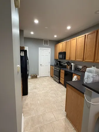 a kitchen with stainless steel appliances granite countertop a refrigerator a stove a sink and a microwave