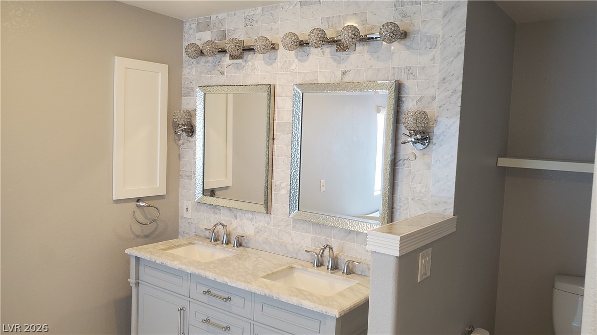 7903 Dell Ridge Avenue Las Vegas, NV 89179 - Photo 12 of 20 Dual vanity with elegant marble counters and textured framed mirrors perfect for morning routines.