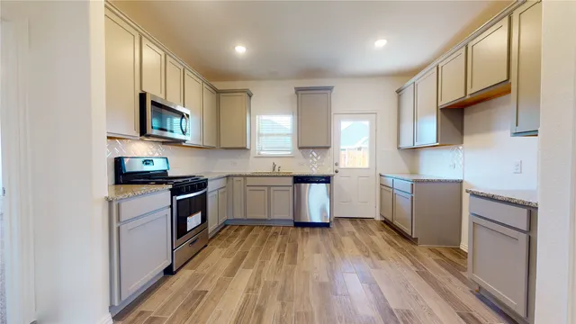 a kitchen with granite countertop a sink and cabinets