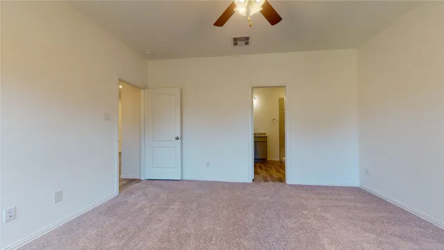 an empty room with chandelier fan