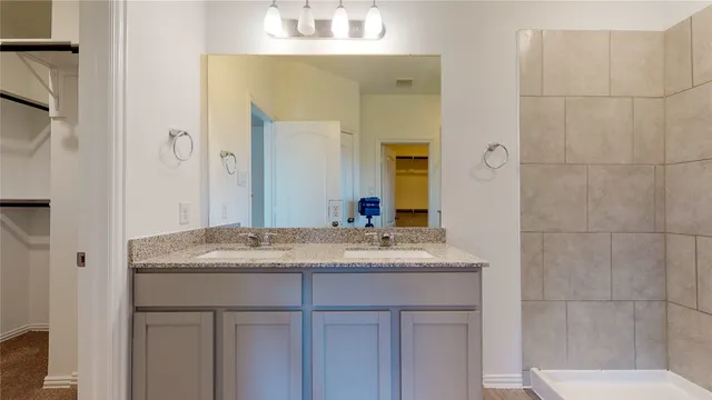 a bathroom with a granite countertop sink and shower