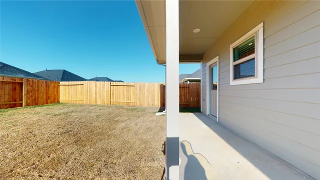 a view of an house with backyard and wooden fence