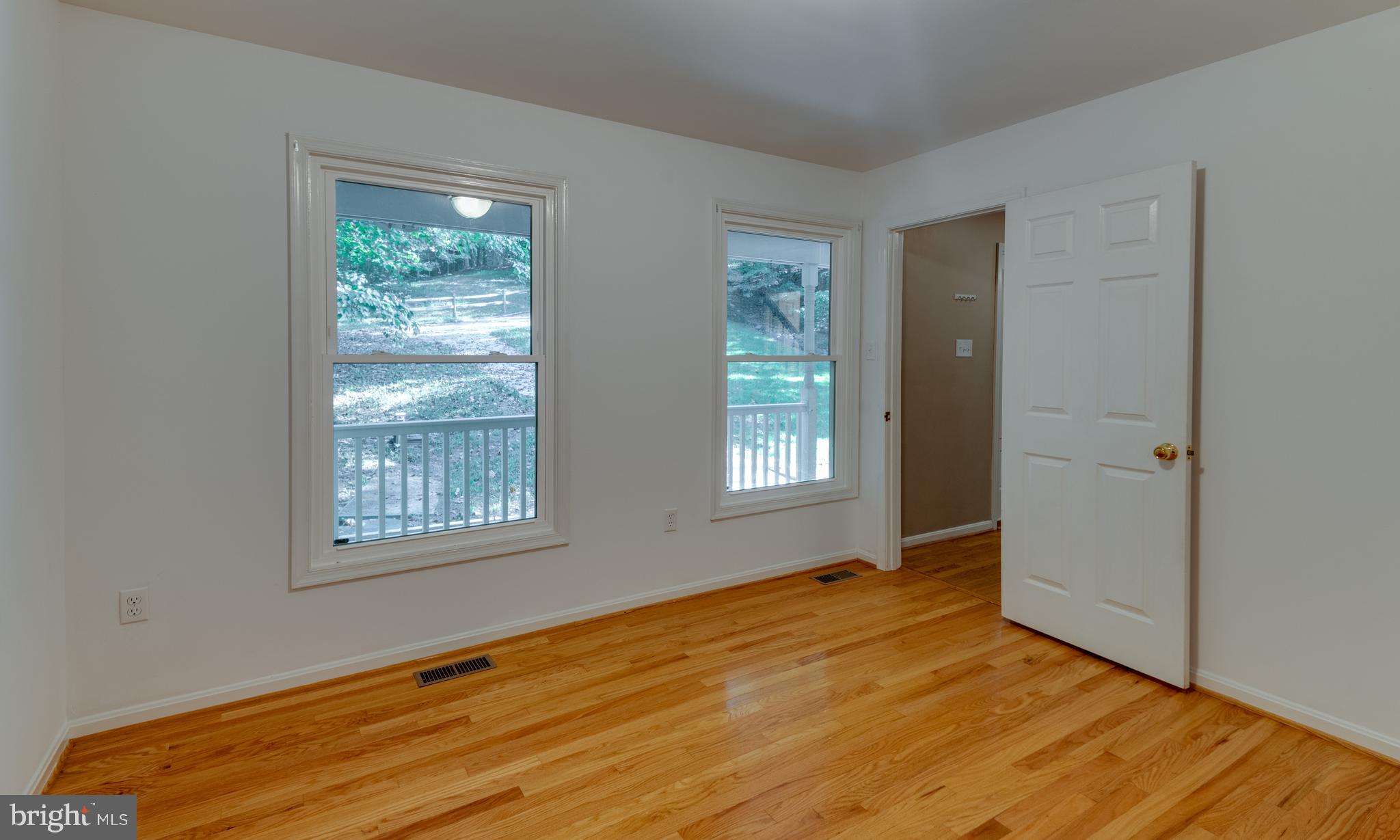 8413 Manor View Road Lusby, MD 20657 - Photo 5 of 48 a view of an empty room with wooden floor and a window