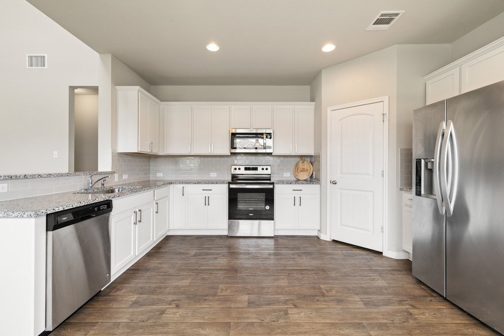 102 Ashford Way Georgetown, TX 78626 - Photo 10 of 28 Culinary delights await in this bright kitchen with ample cabinetry and robust hardwood-style flooring.