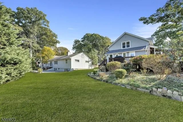 a view of a house with a big yard and large trees