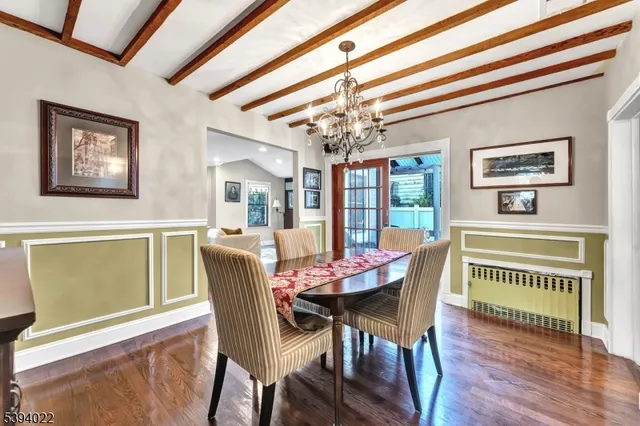 a dining room with furniture a chandelier and wooden floor