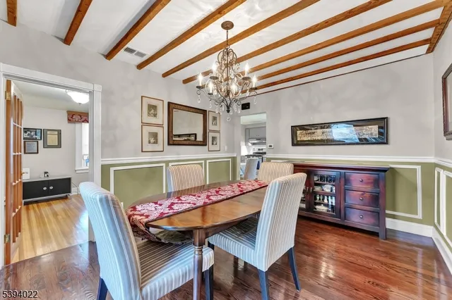 a dining room with furniture a chandelier and wooden floor