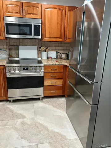 a kitchen with stainless steel appliances a stove and a microwave