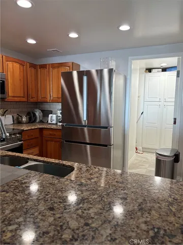 a kitchen with stainless steel appliances granite countertop a refrigerator sink and cabinets