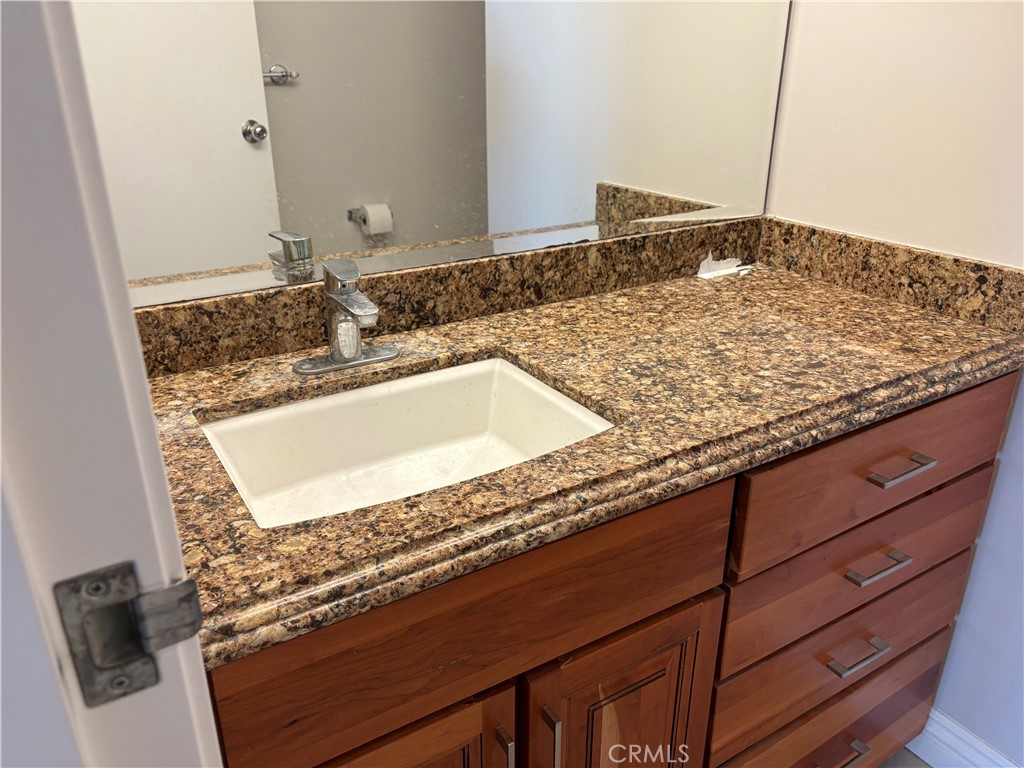 525 East Seaside Way, Unit 1505 Long Beach, CA 90802 - Photo 10 of 47 a bathroom with a granite countertop sink and a mirror
