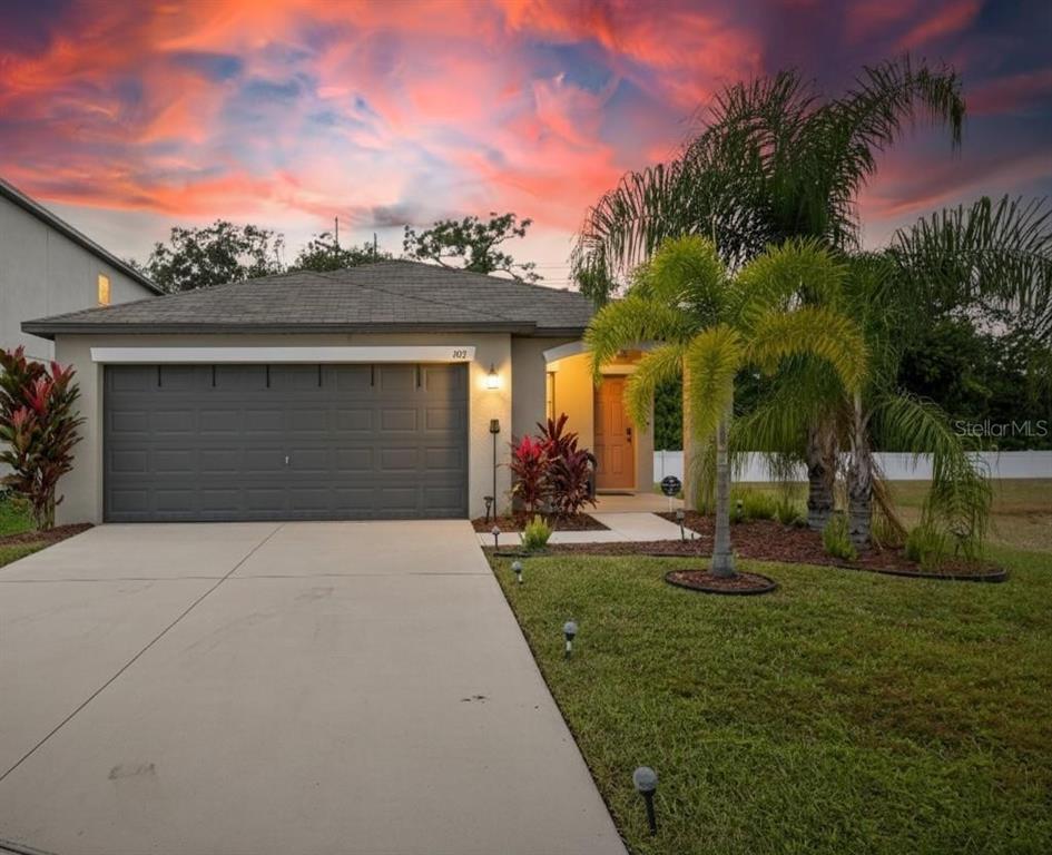 a front view of a house with a yard and garage