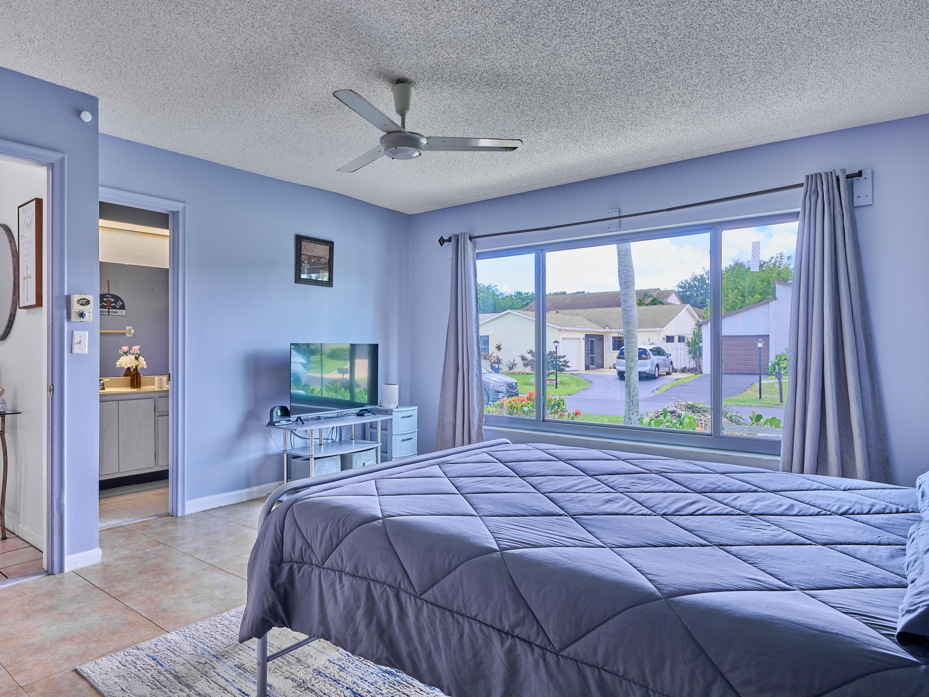 5197 Minto Road Boynton Beach, FL 33472 - Photo 16 of 32 a bedroom with a large bed and a large window