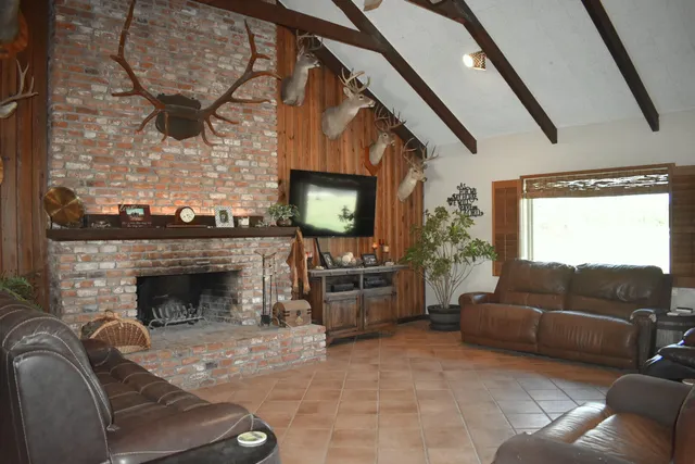 a living room with furniture a fireplace and a flat screen tv