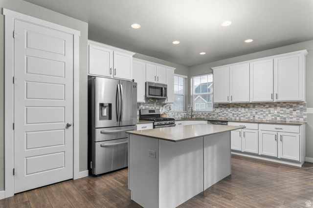 5686 Duke Lane Tooele, UT 84074 - Photo 2 of 38 Kitchen with stainless steel appliances, a kitchen island, backsplash, dark wood finished floors, and recessed lighting