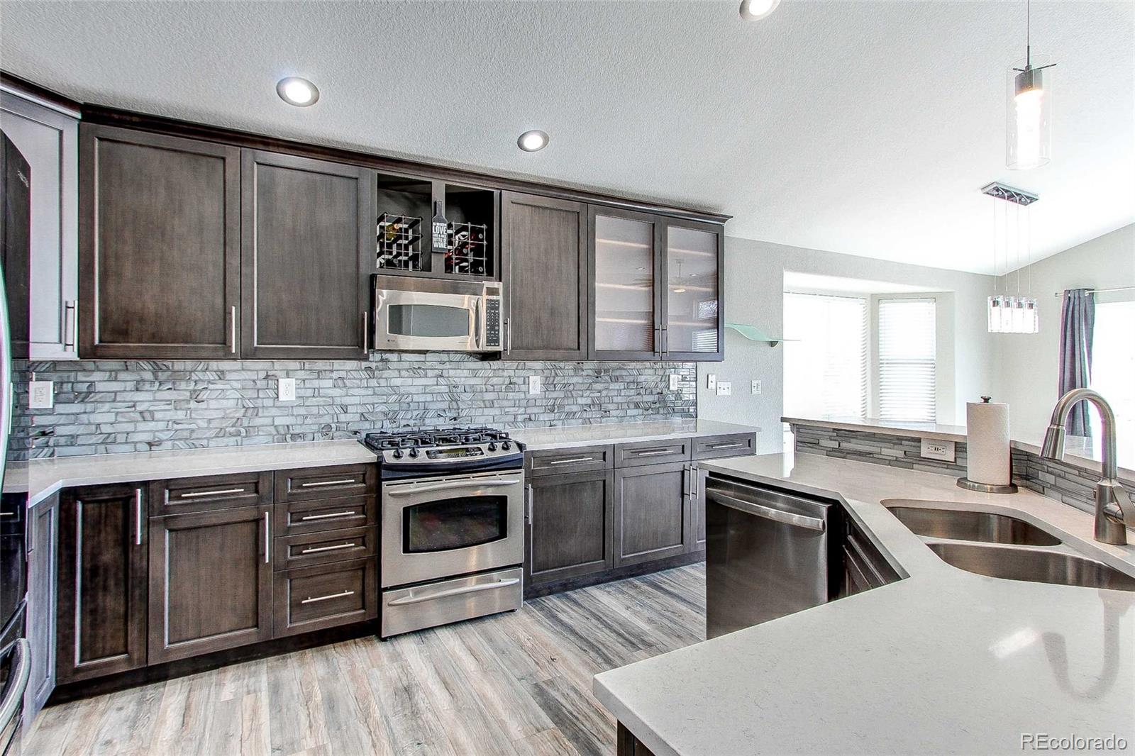 16082 Butterwort Circle Parker, CO 80134 - Photo 12 of 39 a kitchen with stainless steel appliances granite countertop a sink stove and cabinets