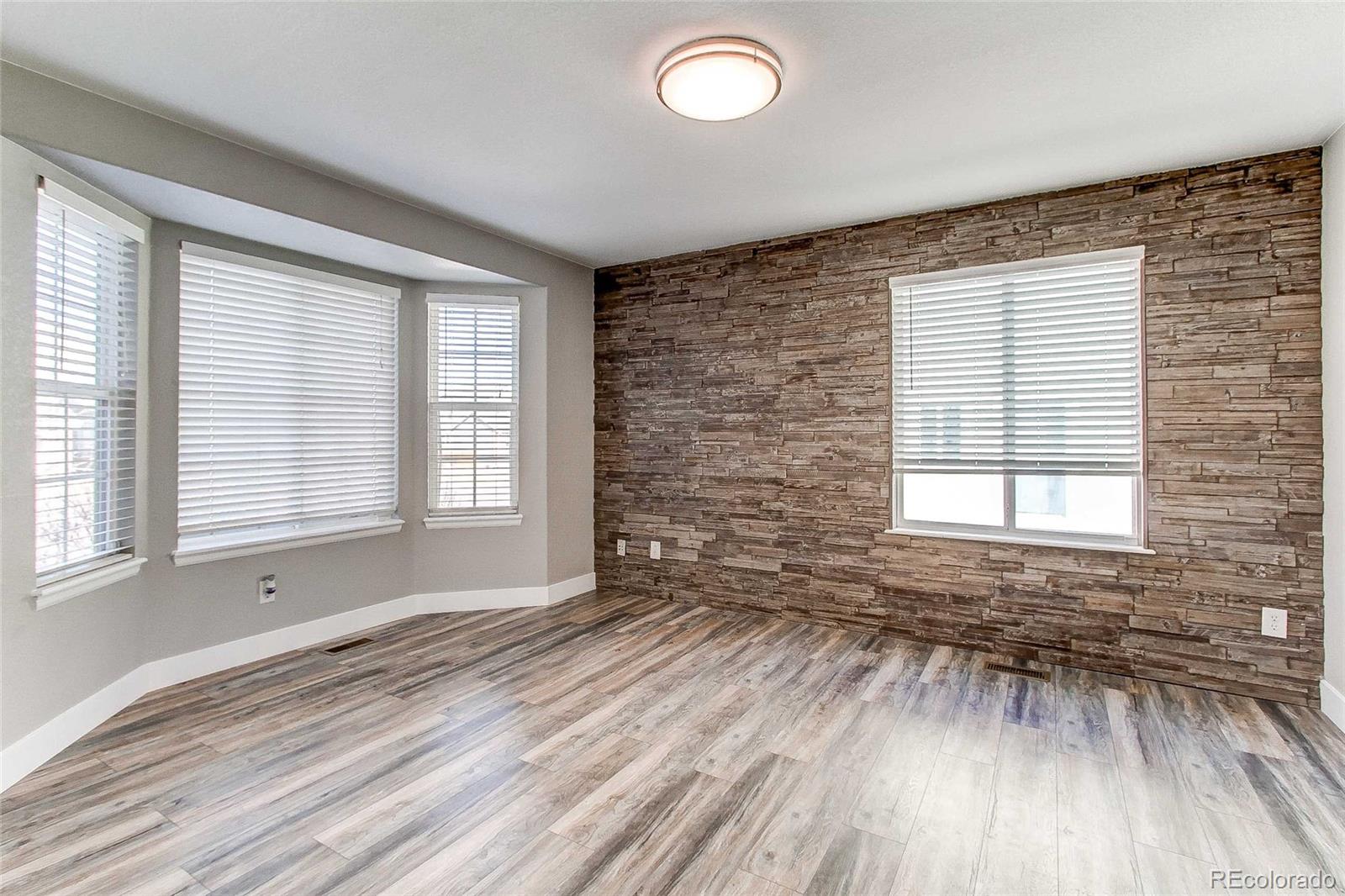 16082 Butterwort Circle Parker, CO 80134 - Photo 5 of 39 an empty room with wooden floor and windows