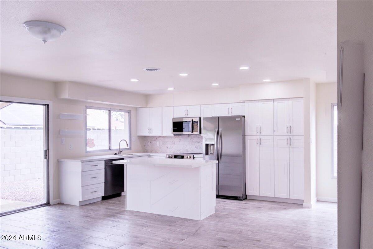 2732 East Cactus Road Phoenix, AZ 85032 - Photo 12 of 30 a kitchen with stainless steel appliances a sink a stove a refrigerator and cabinets