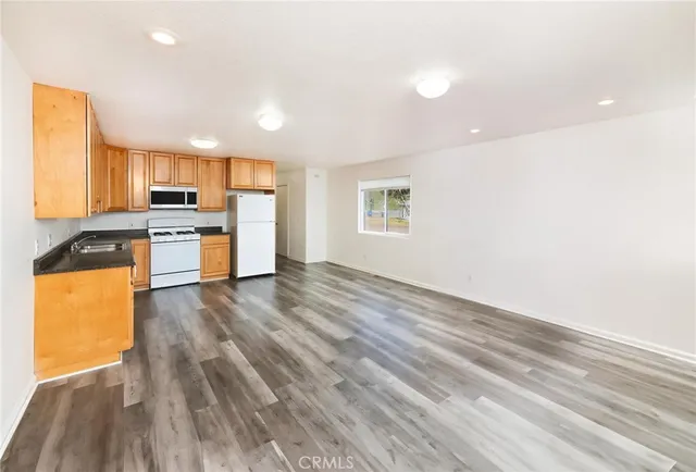 a view of a kitchen with a sink a refrigerator and window