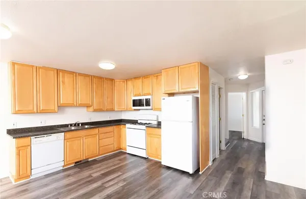 a kitchen with a refrigerator and wooden cabinets
