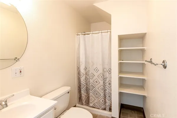 a bathroom with a toilet and a shower curtain